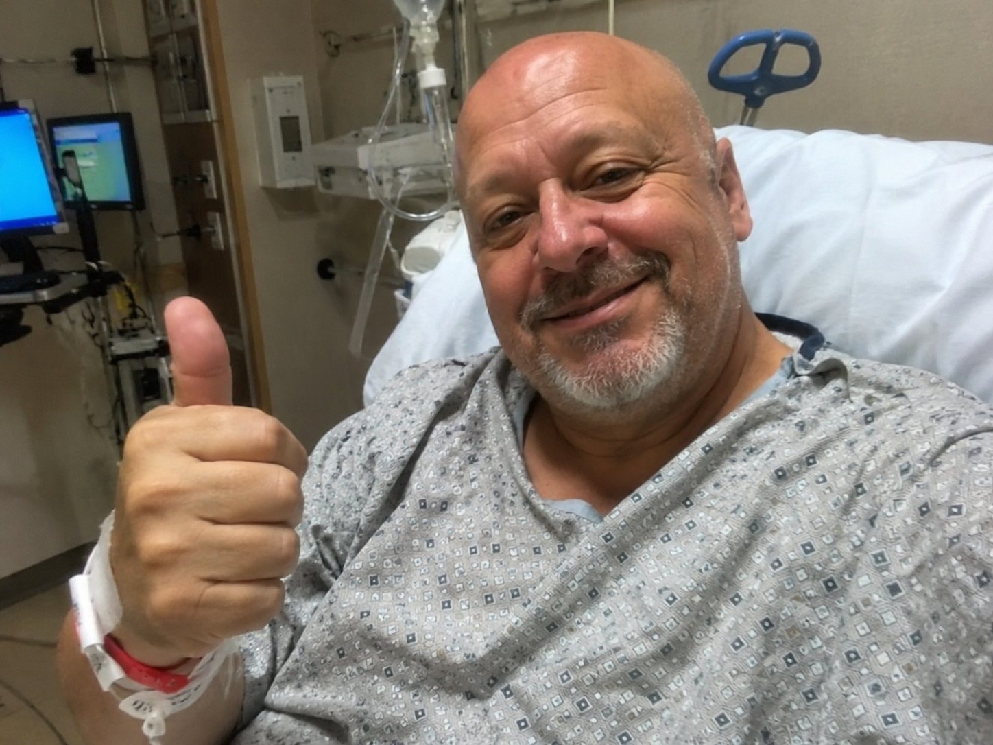 A patient giving a thumbs up in recovery