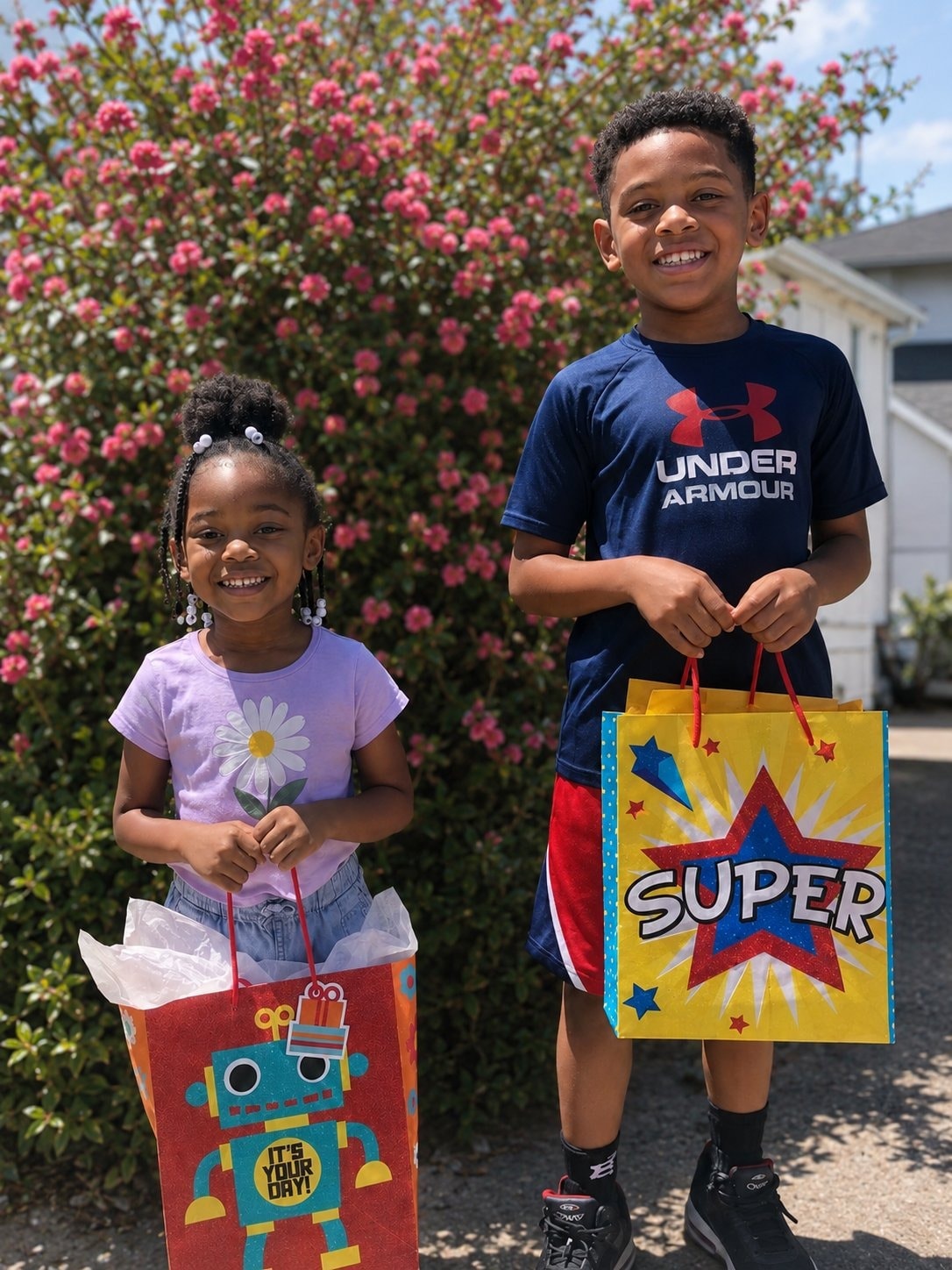 Two children smiling with gift bags